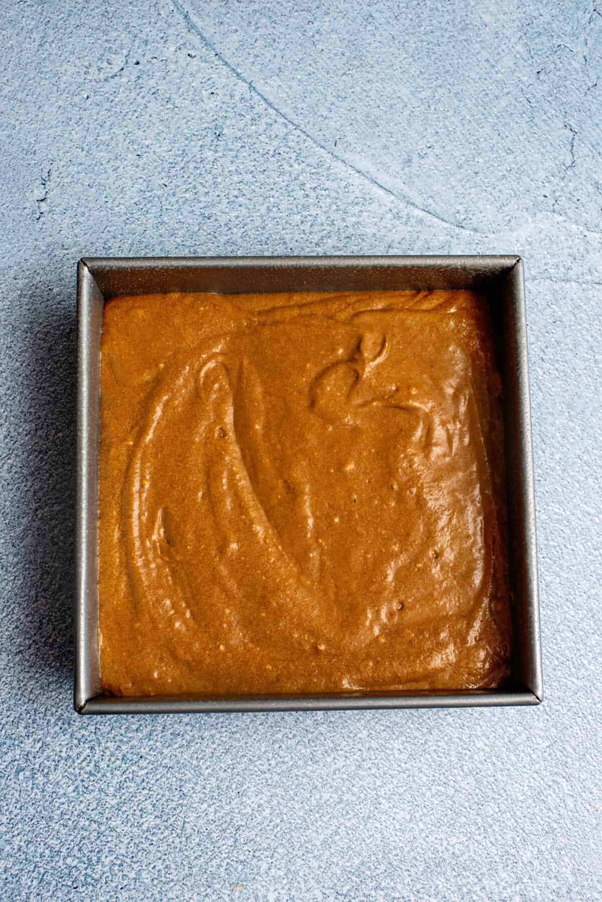 spread simple gingerbread snack cake batter in the cake pan