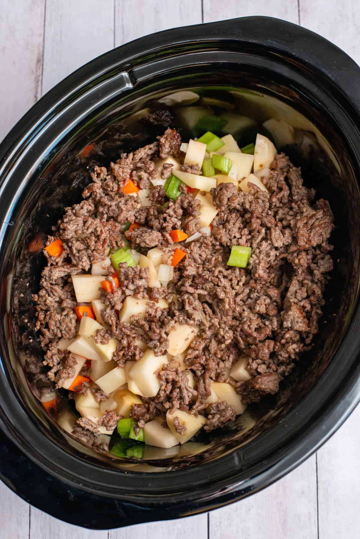 add ground beef to the crockpot and vegetables