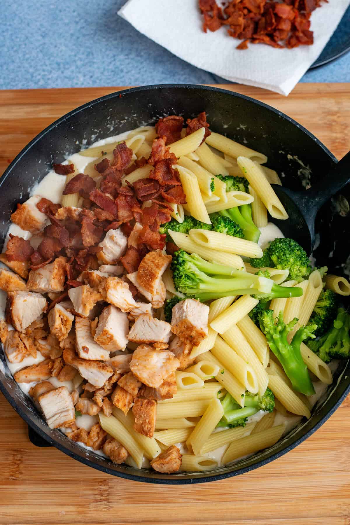 Add chicken, broccoli pasta and bacon to skillet