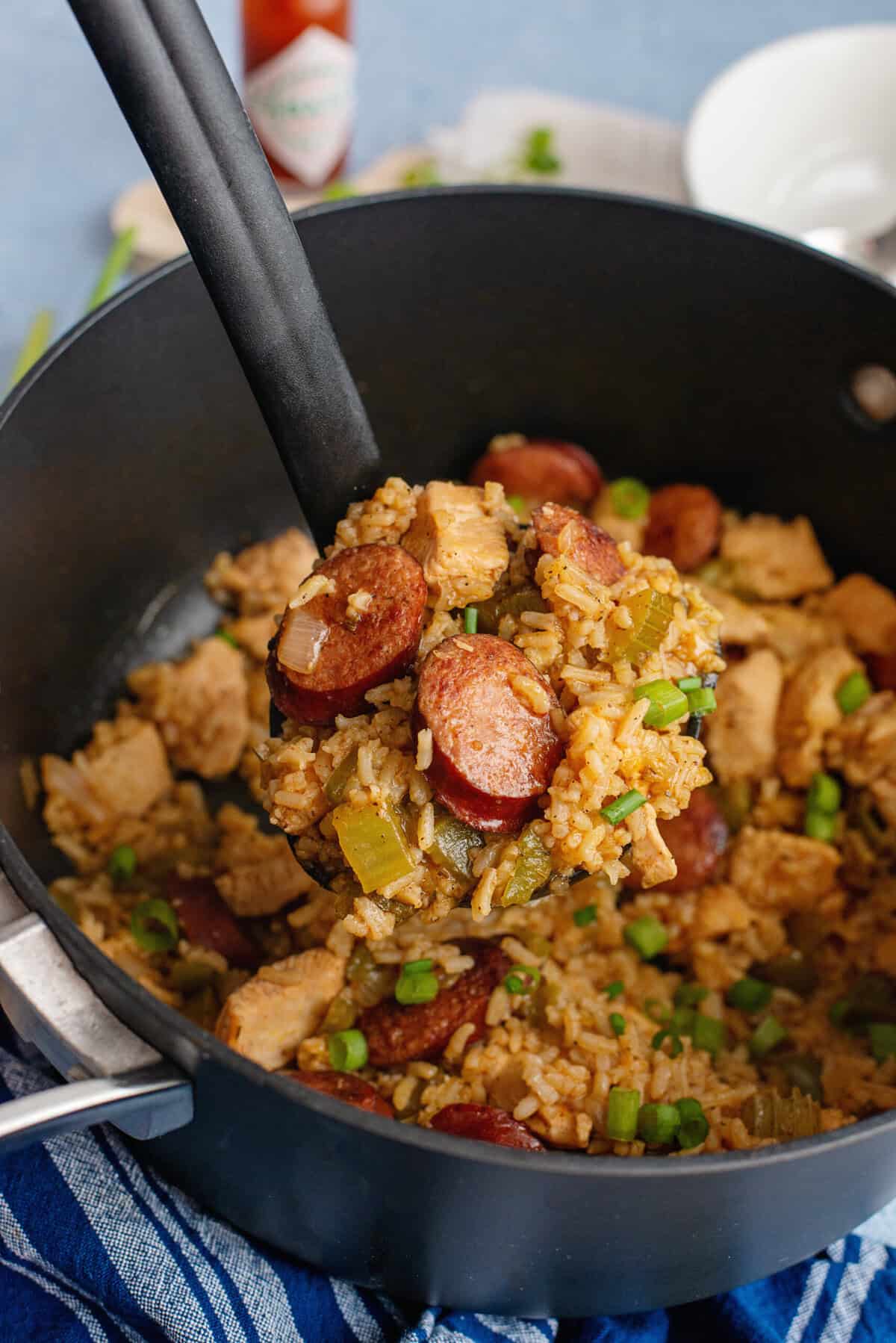 Skillet filled with Cajun jambalaya featuring chicken, sausage, and rice.