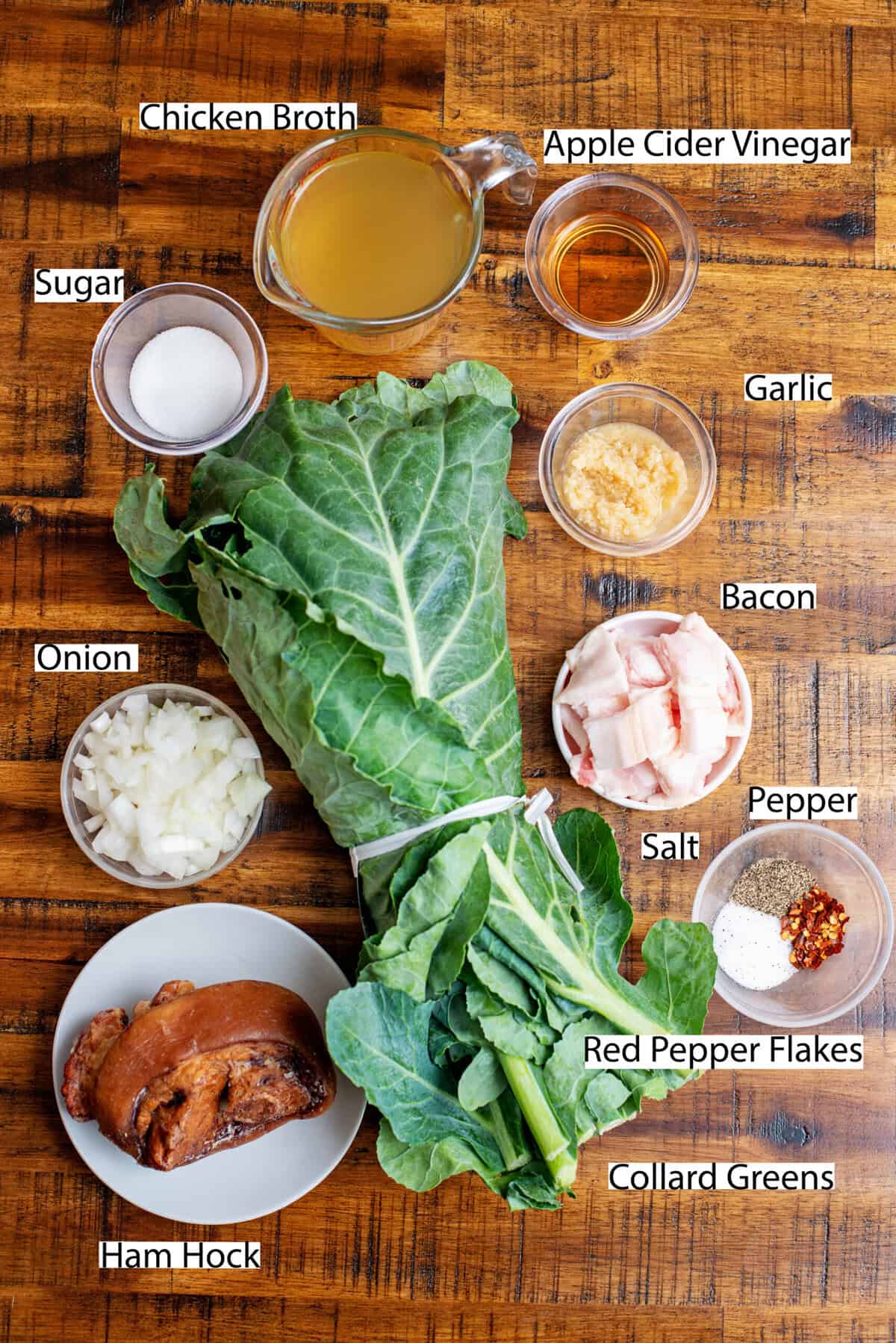 Ingredients for collard greens recipe on a wooden surface.